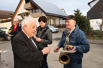 Pfarrer Pitzal teilt Brot mit der Musikgruppe des MVM 1